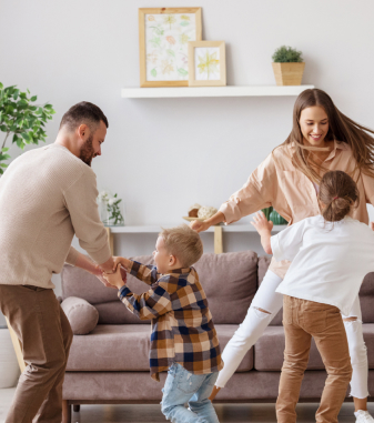 A happy family dancing in their home