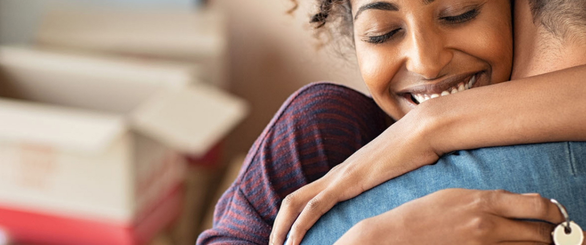 A couple hugging with keys to their new house